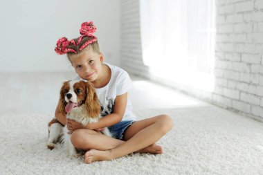 Happy child girl with a dog. The child and the dog are having fun playing at home. High quality photo