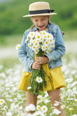 Tarlada elinde çiçeklerle mutlu bir kız. Yüksek kalite fotoğraf