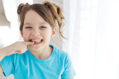 The child has lost a tooth. Little girl without a tooth. The first tooth fell out. High quality photo