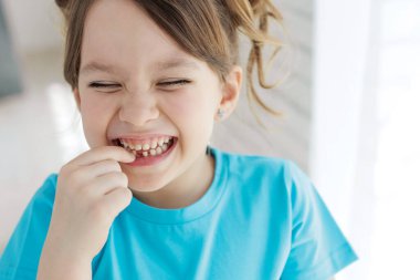 The child has lost a tooth. Little girl without a tooth. The first tooth fell out. High quality photo