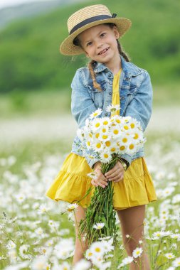Tarlada elinde çiçeklerle mutlu bir kız. Yüksek kalite fotoğraf