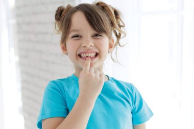 The child has lost a tooth. Little girl without a tooth. The first tooth fell out. High quality photo