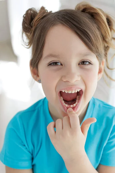 The child has lost a tooth. Little girl without a tooth. The first tooth fell out. High quality photo