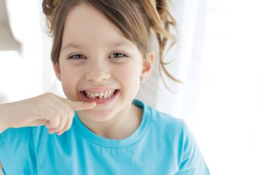 The child has lost a tooth. Little girl without a tooth. The first tooth fell out. High quality photo