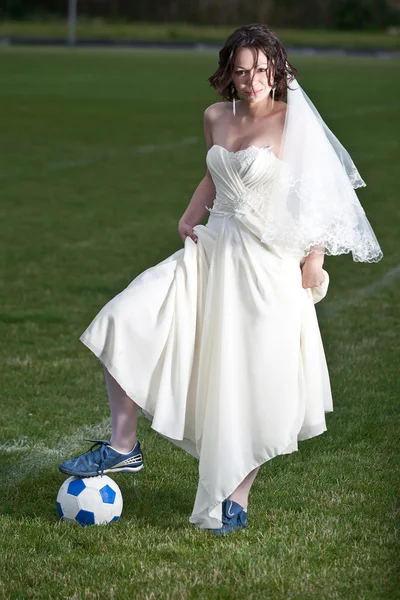 Braut im weißen Kleid auf einem Fußballplatz. — Stockfoto