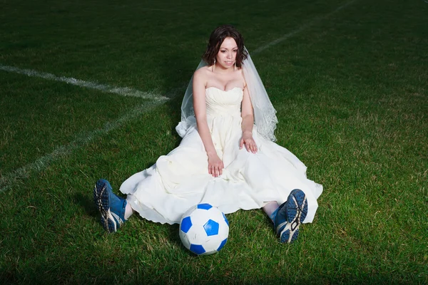 Braut im weißen Kleid auf einem Fußballplatz. — Stockfoto