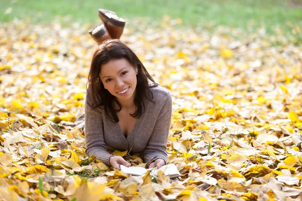 Leuk meisje met herfst achtergrond. — Stockfoto