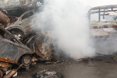 Birçok kişi Irpin, Ukrayna 'daki araba mezarlığında arabaları vurup imha etti..
