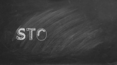Lettering STOP WAR hand drawn in chalk on a school blackboard.