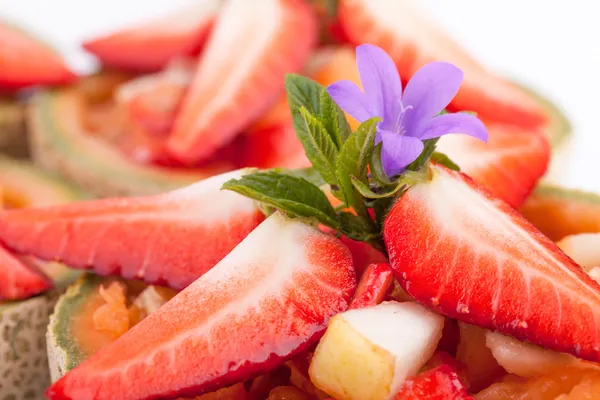 Aardbei stukken op de top van fruit salade — Stockfoto