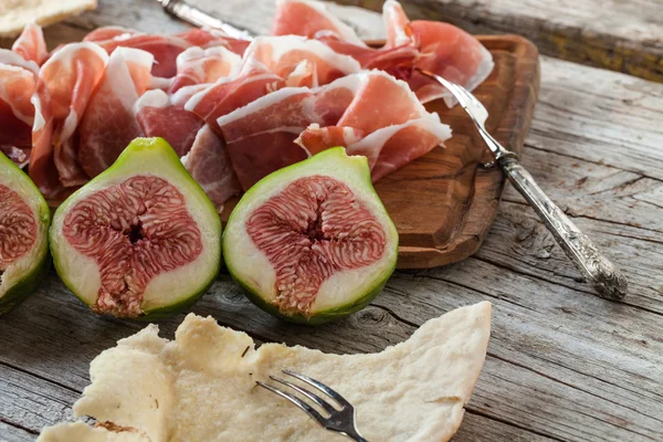 Figues fraîches avec jambon sur une assiette blanche — Photo