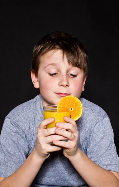 Menino com suco de laranja — Fotografia de Stock