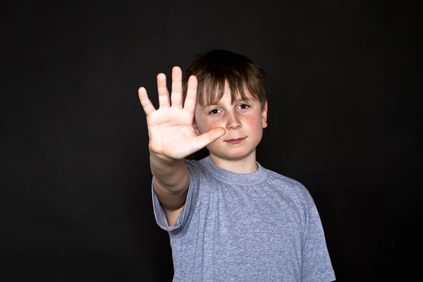 Хлопчик показує руку, щоб зупинитися — стокове фото