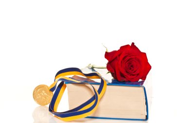 gold medal with a book and flowers