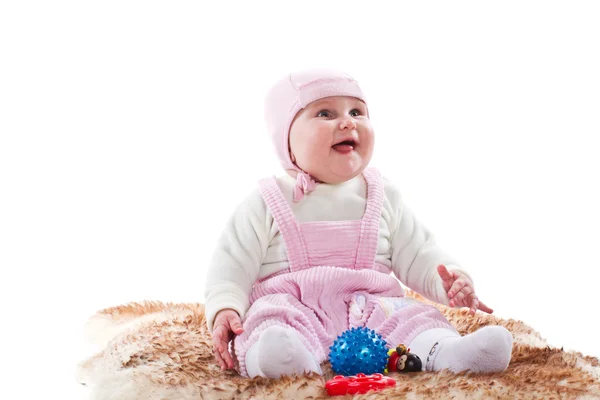 장난감으로 모피 양탄자에 앉아 어린 소녀 — 스톡 사진