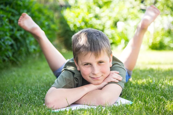 Boy with a book on the grass — Stock Photo, Image