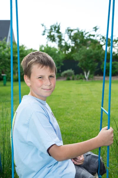 Teenager sitting on a swing — Stock Photo, Image