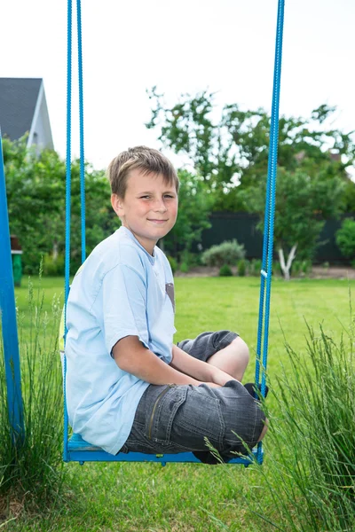 Tiener zittend op een schommel Rechtenvrije Stockfoto's