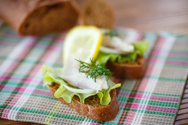 Sandwich salted herring and lettuce — Stock Photo, Image