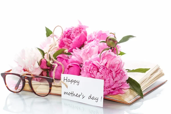 Bouquet of peonies  on old book with glasses — Stock Photo, Image