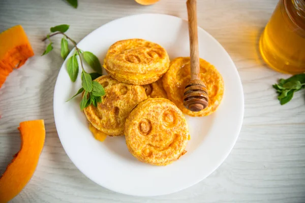 Söt frodig pumpa pannkakor med honung i en tallrik — Stockfoto