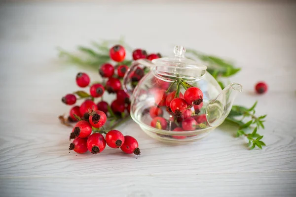 Ripe red rose hips on a wooden table — Stock Photo, Image