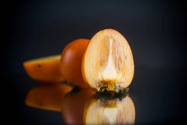Rijp gesneden halve persimmon geïsoleerd op zwart — Stockfoto