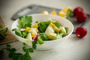 Taze salata, taze marul yaprakları, turplar, ahşap bir masada kaynamış yumurtalar.