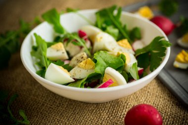 Taze salata, taze marul yaprakları, turplar, ahşap bir masada kaynamış yumurtalar.