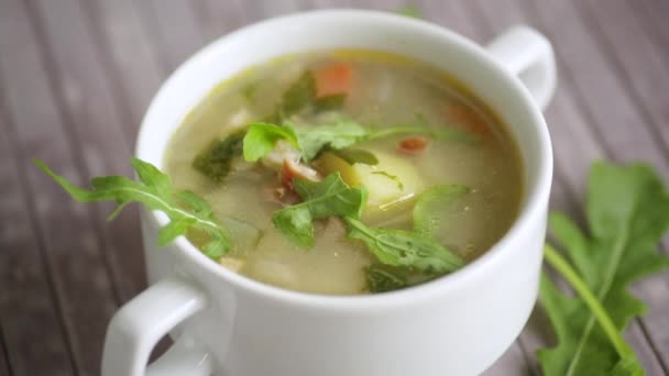 Літній легкий суп з вівсянкою і руколою в тарілці — стокове відео