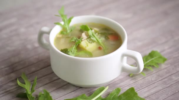 Nyári könnyű leves zabpehellyel és arugulával egy tányéron — Stock videók