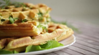 Ev yapımı kızarmış sebze waffle 'ları ve içinde de ahşap bir masada otlar.