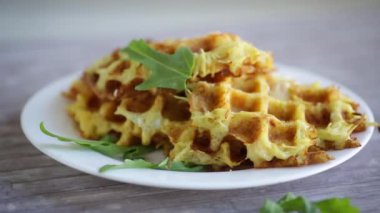 Hafif ahşap bir masada peynirli kızarmış patates waffle 'ları..