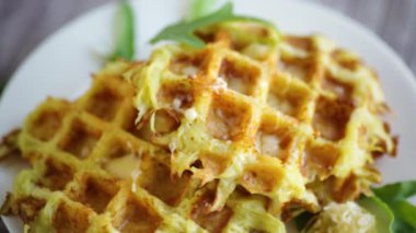 Hafif ahşap bir masada peynirli kızarmış patates waffle 'ları..