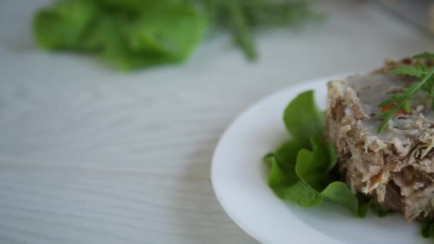 木のテーブルの上の皿に緑と野菜を盛ったゼリー状の肉 — ストック動画