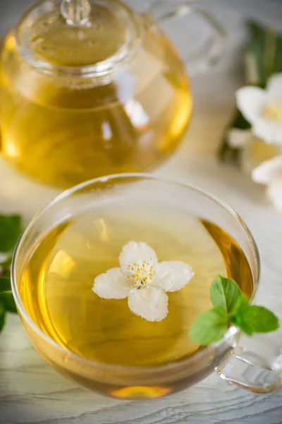 配上一杯茉莉花茶和浅色背景的花 — 图库照片