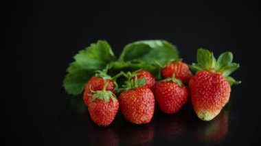 Olgun sulu kırmızı çilek siyah arkaplanda izole