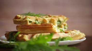 Ev yapımı kızarmış sebze waffle 'ları ve içinde de ahşap bir masada otlar.