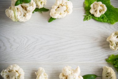 Hafif ahşap bir masa üzerinde küçük çiğ karnabahar kabartmaları