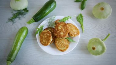 Kabak ve kabaktan kızartılmış sebze krepleri, hafif ahşap bir masada..
