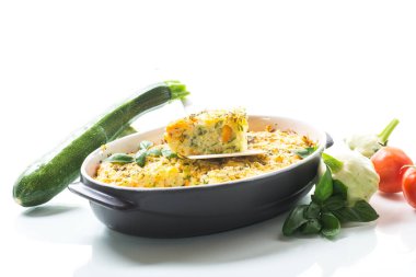 vegetable casserole of patissons, zucchini, carrots in a ceramic form isolated on a white background