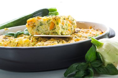 vegetable casserole of patissons, zucchini, carrots in a ceramic form isolated on a white background
