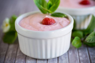 Tahta bir masada taze çilek ile çırpılmış tatlı kaymak yığını..
