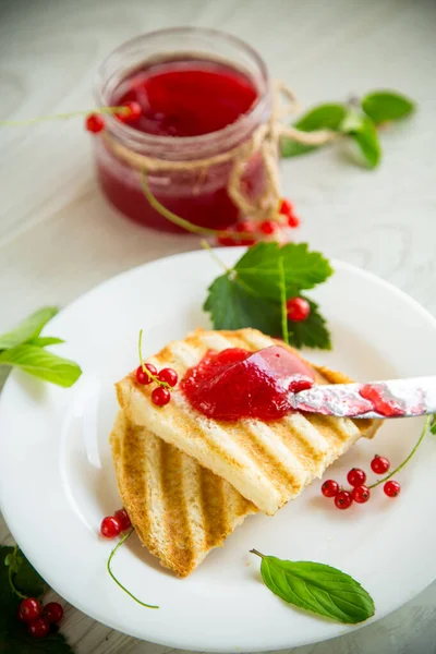 Kahvaltıda kızarmış ekmek ve ahşap bir masada böğürtlenli reçel..