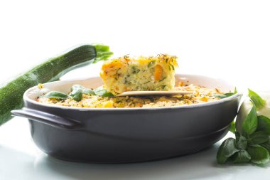 vegetable casserole of patissons, zucchini, carrots in a ceramic form isolated on a white background