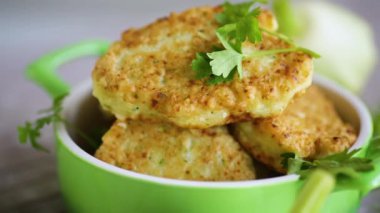 vegetable fried squash and zucchini cutlets in a ceramic form on a light wooden table