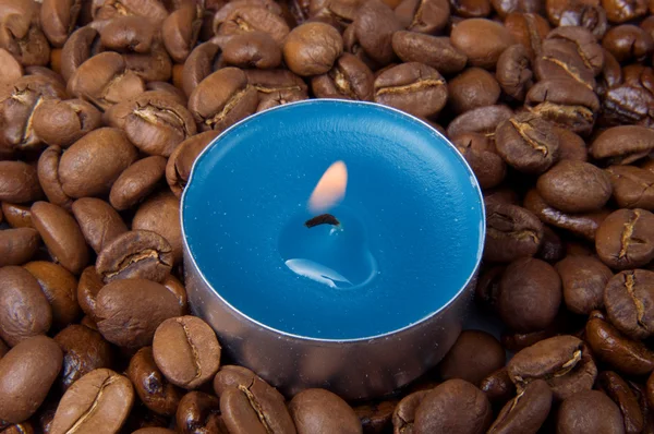 Vela ardiente y granos de café — Foto de Stock