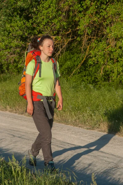 Gelukkig lachende vrouw in veld. groen gras in de voorgrond en heldere hemel op achtergrond. — Stockfoto