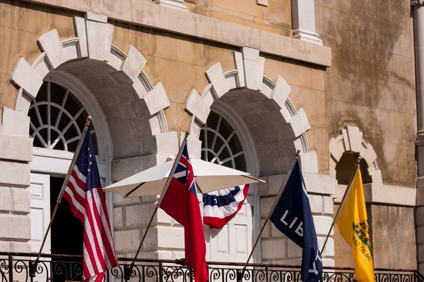 Banderas ondeando frente a un edificio — Foto de Stock