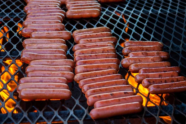 Reihen von Hot Dogs auf dem Grill Stockfoto